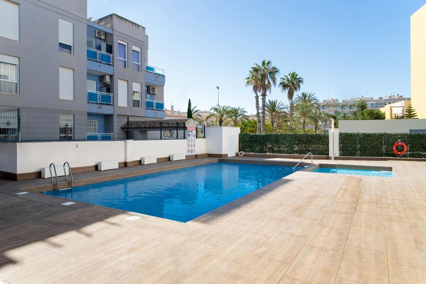 Gemeinschaftspool der Wohnanlage mit Palmen und Sonnenterrasse in Torrevieja